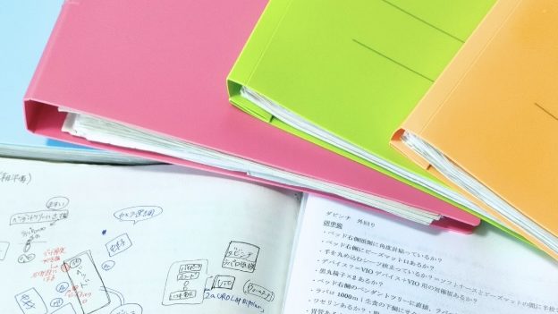 色とりどりのファイルと、手書きのマインドマップ風ノート
